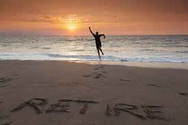 Figure on beach at sunset, "retirement" carved in the sand