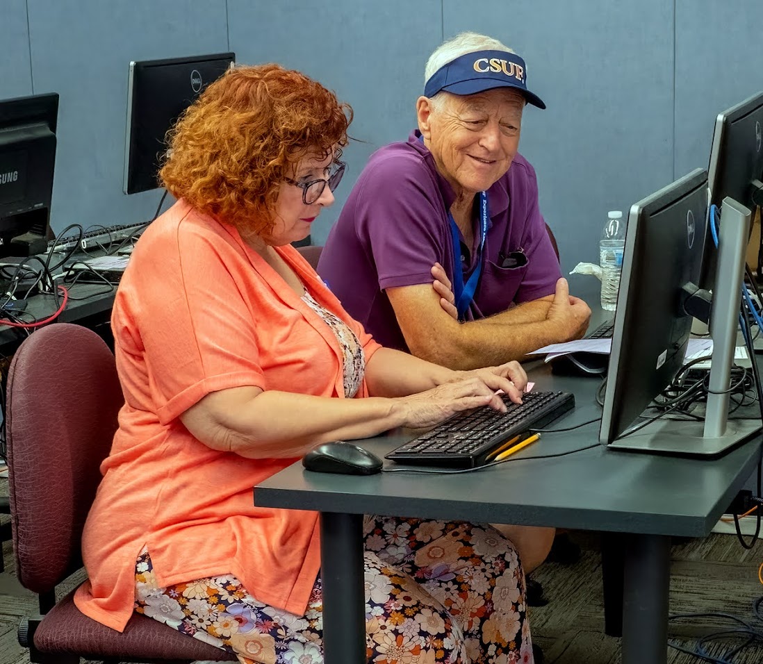 two olli members working on a computer